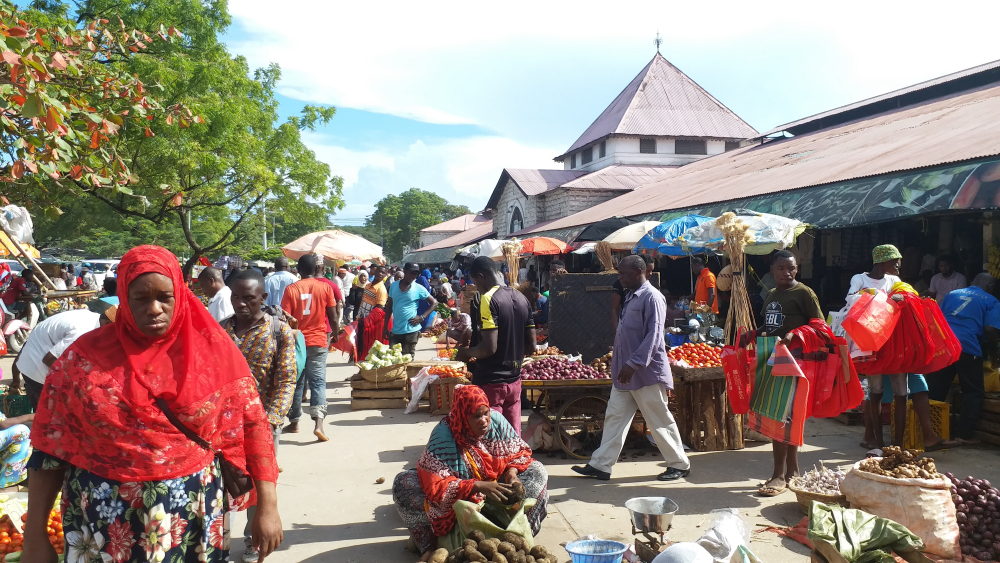 people passing and buying at darajani market