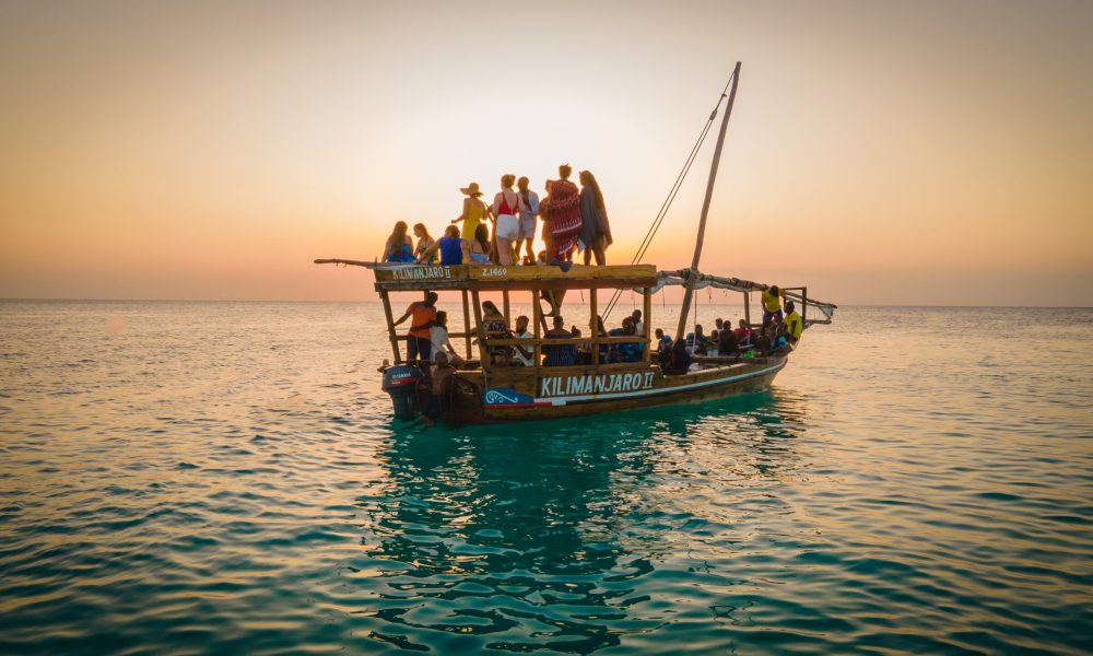 Nungwi Beach, Zanzibar - Tanzania - June 18 2022 - fishing Boats  with tourist on the indian ocean during sunset.
